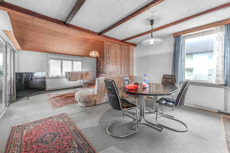 Open floor plan, TV, table and chairs, sofa, wooden ceiling, carpet