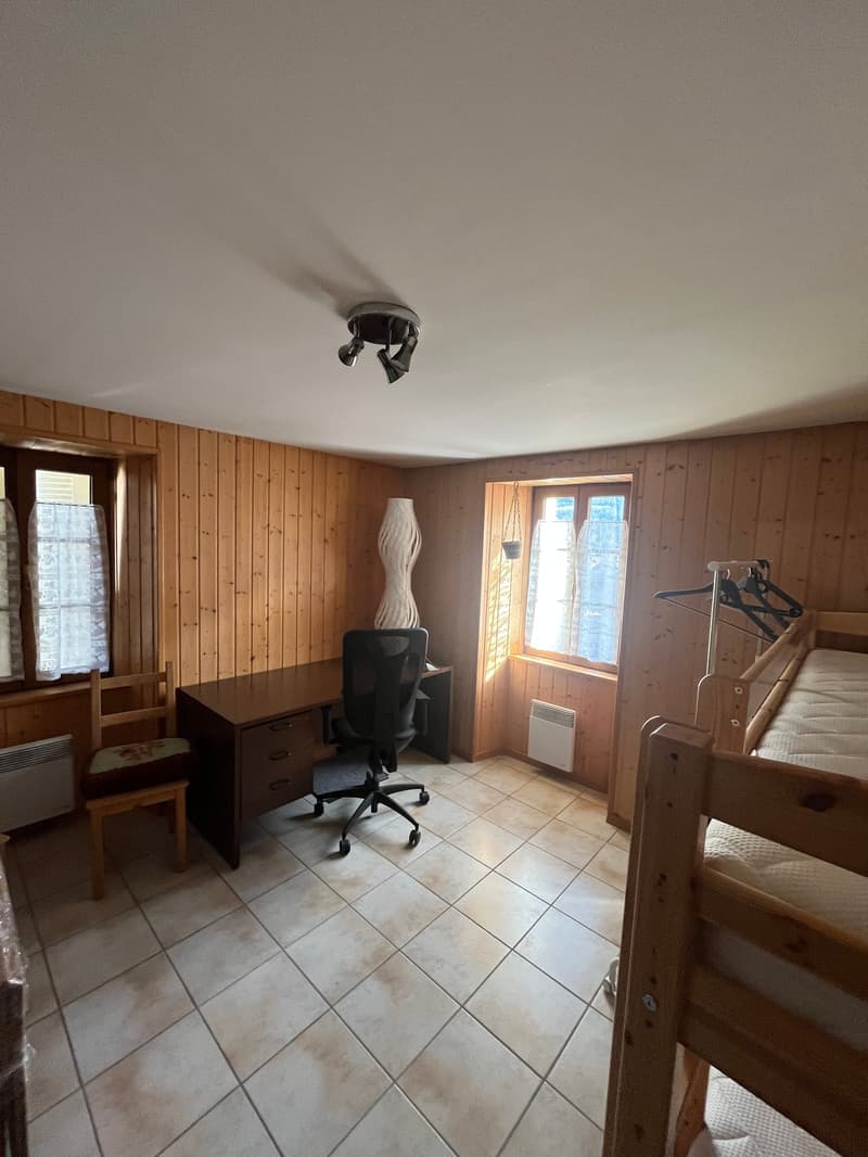 wooden walls, white tile floor, desk, chair, bunk bed, radiator, windows with curtains