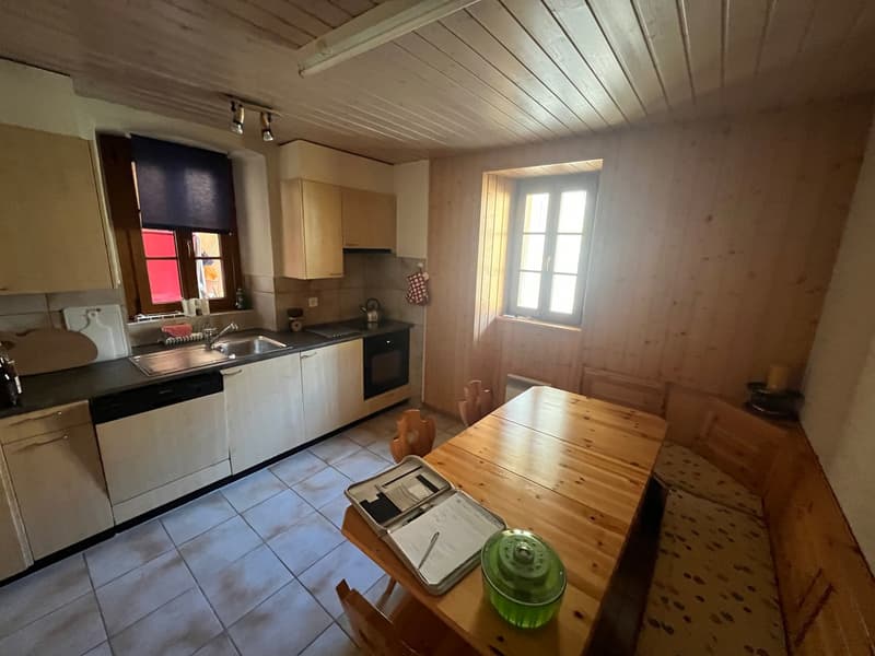 kitchen with wooden cabinets, sink, oven, dishwasher, dining table, wooden chairs, wooden bench, tiled floor
