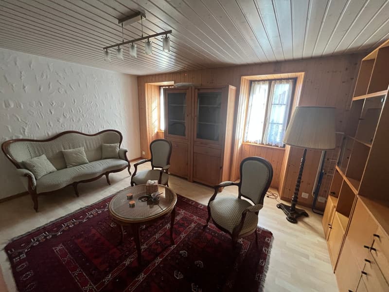 living room with sofa, chairs, coffee table, wooden cabinets, wooden floor, wooden ceiling, windows, lamp