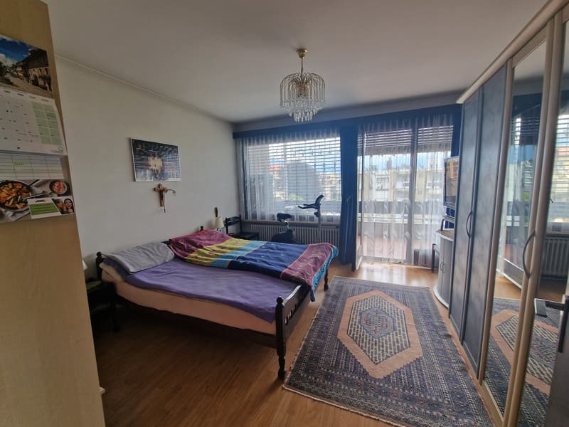 bedroom with bed, rug, wardrobe, balcony, chandelier, radiator, picture, calendar, cross