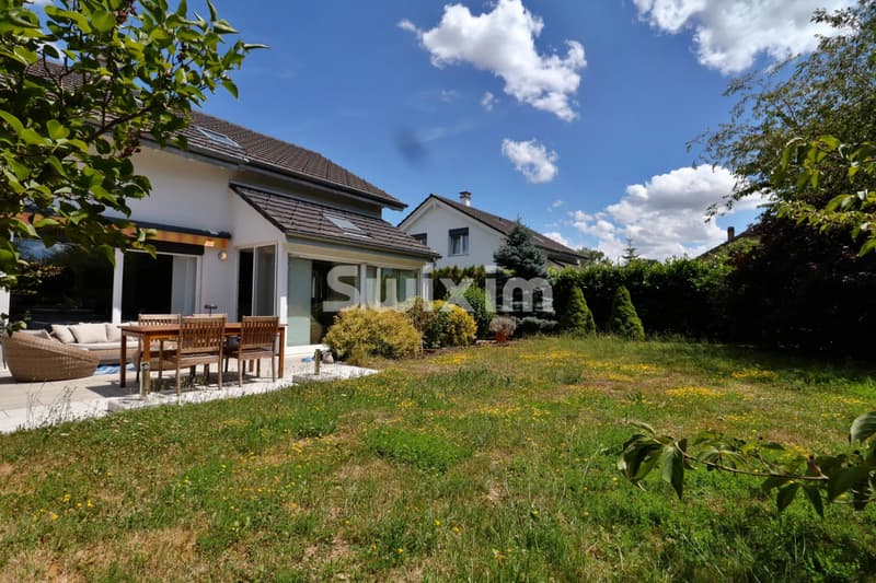 Belle maison avec jardin spacieux et terrasse ensoleillée.