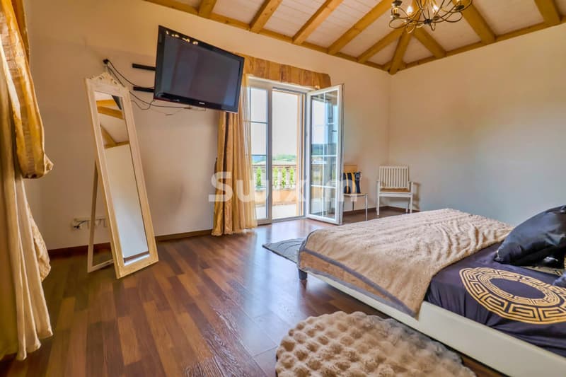 Chambre lumineuse avec terrasse, télévision et mobilier charmant.