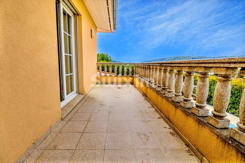 Grand balcon offrant une vue panoramique ensoleillée.