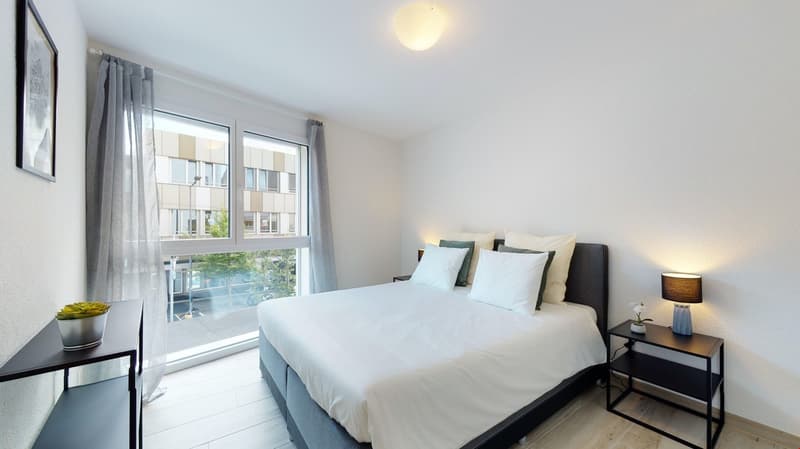 large bed, white bedding, pillows, bedside tables with lamps, indoor plant, large window with city view
