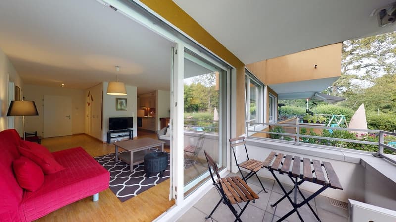 Living area with couch and table, balcony with chairs and table, kitchen and dining table