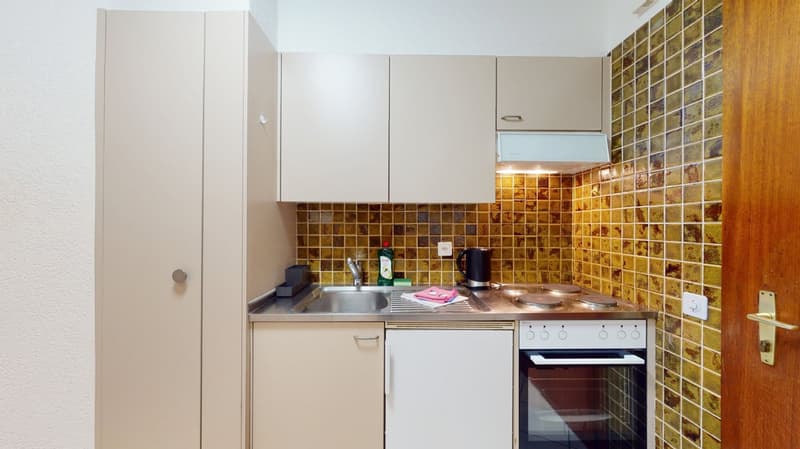 Small kitchen with white cabinets, stainless steel sink, tiled backsplash, and a dishwasher