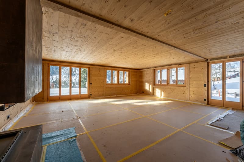 Empty room with wooden wall and floor, big windows and balcony
