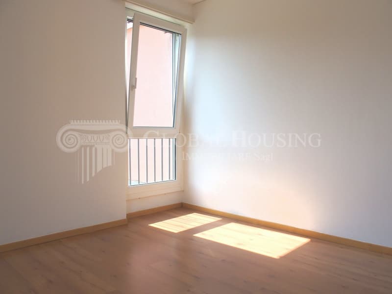 empty room with window, balcony, wooden floor, white walls
