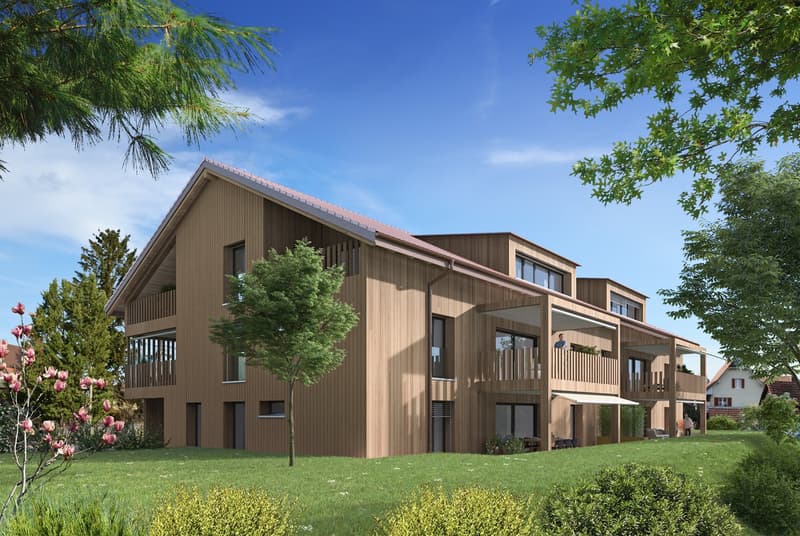 Multi-story apartment building with wooden siding, balconies, and large windows. The building is surrounded by lush greenery, including trees and shrubs.