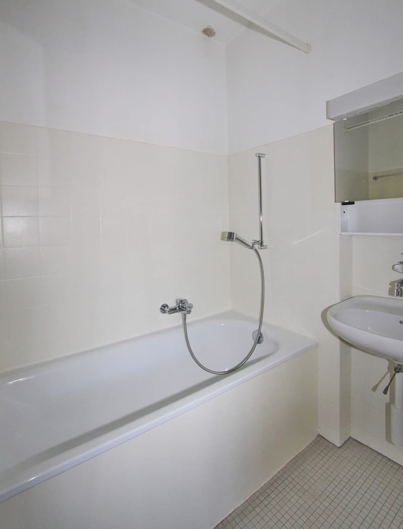 Bathroom with bathtub, sink, and mirror
