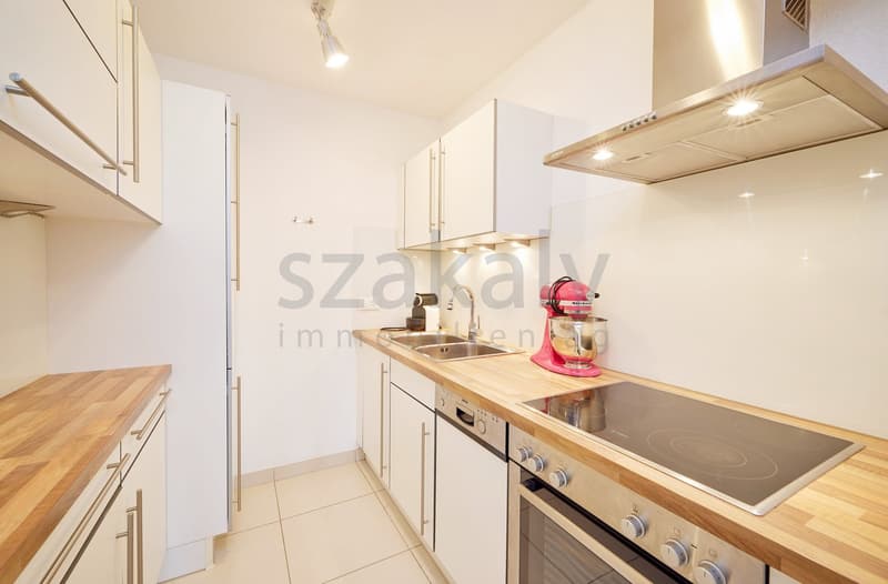 modern kitchen with white cabinets, wooden countertops, induction stove, oven, sink, dishwasher, mixer, refrigerator