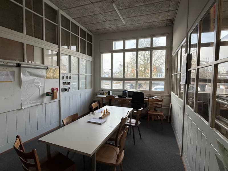 office room with desk, chairs, table, large windows