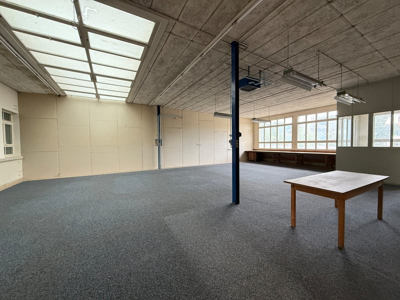 empty room with concrete floor, 4 metal beam support, glass ceiling, tables, benches