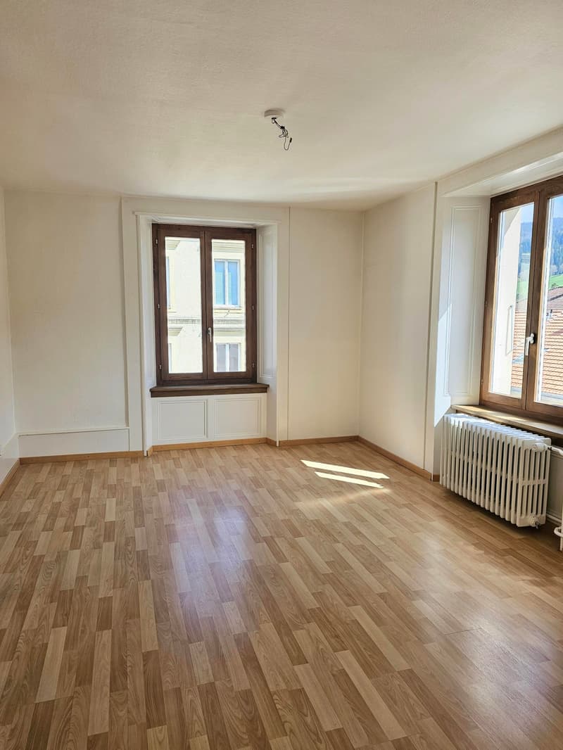 empty room, wooden floor, white walls, two windows, radiator