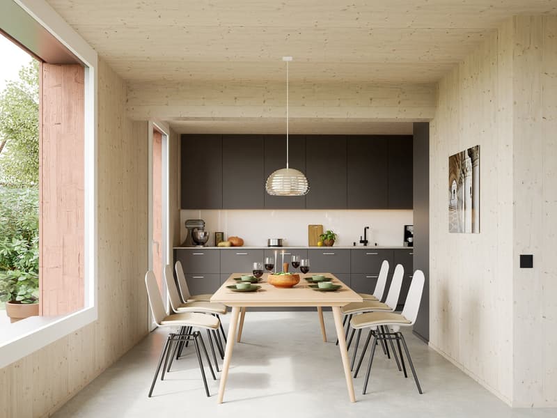 Dining room with wooden table, white chairs, pendant light, wooden walls, large window, kitchen area with appliances