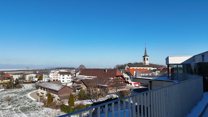 top down aerial view of buildings in town, covered in snow, church visible
