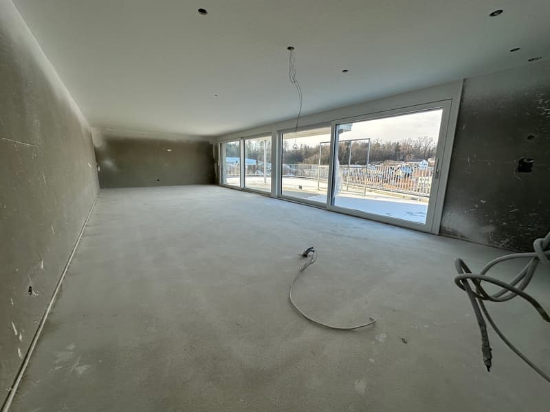 Unfinished room with cement floor, glass sliding doors, balcony