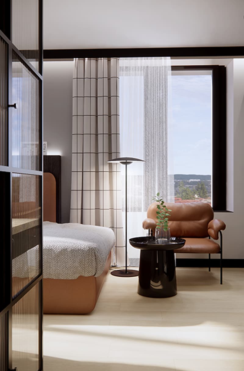Single bed with a beige linen, wooden floor, white walls, large window, chair with side table, plant
