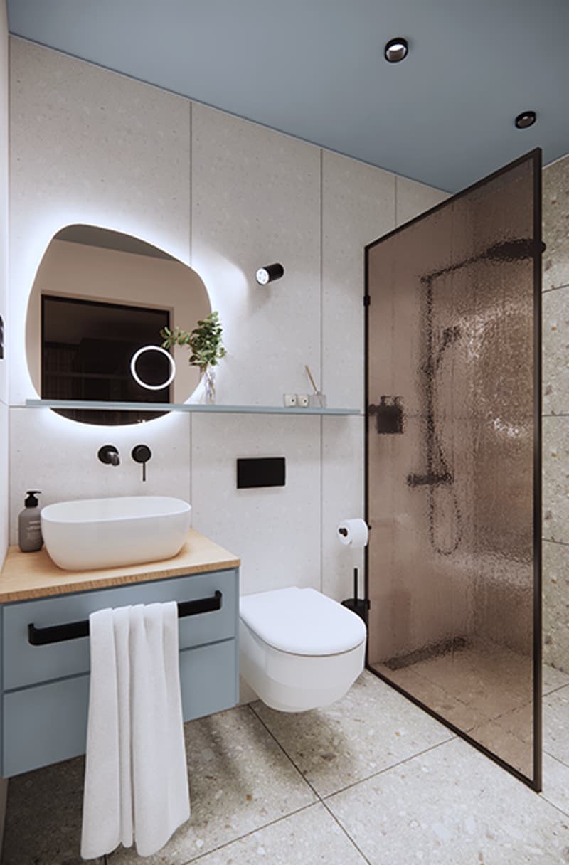 Modern bathroom with white sink, blue drawer, circular mirror, walk-in shower, and towel