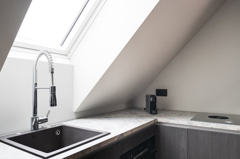 marble countertop, modern sink with faucet, built-in coffee machine, induction cooktop, skylight window, grey cabinets