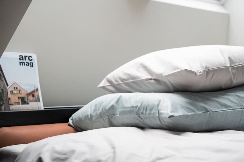 Unmade bed with two pillows and bed sheet on top