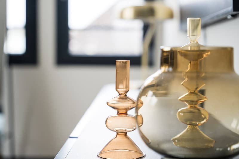 A table with three glass objects, one with a lamp behind it