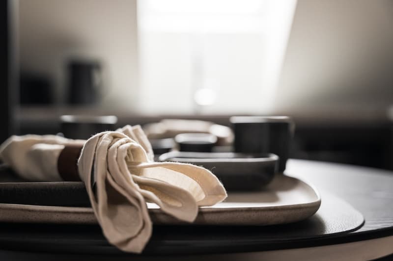 plates, cups, bowls, white napkin, dark setting