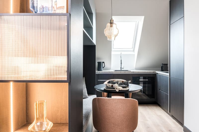 small kitchen, round table, single chair, round pendant light, countertop, sink, oven, bench, storage