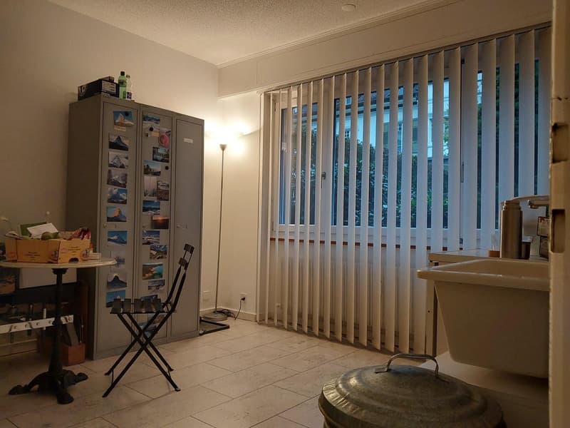 kitchenette, small table, folding chair, storage cabinet, floor lamp, closed blind, sink, trash bin