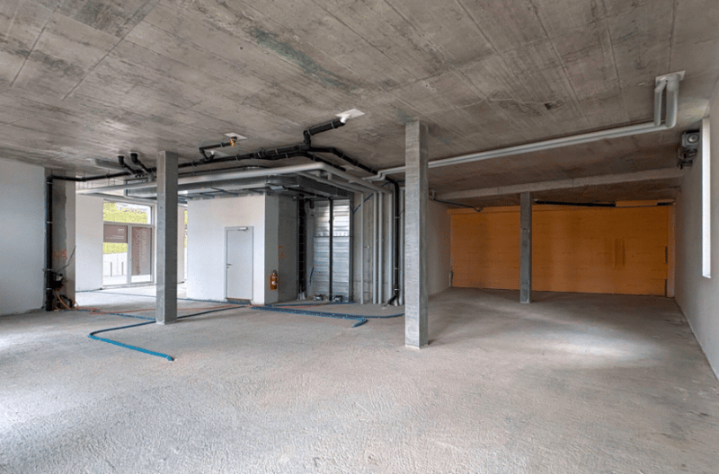 empty room, unfinished walls and ceiling, metal beams, cables, fire extinguisher