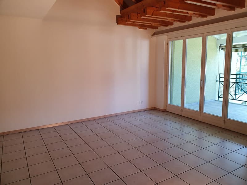 empty room, white walls, tiled floor, double glass doors leading to balcony, wooden ceiling