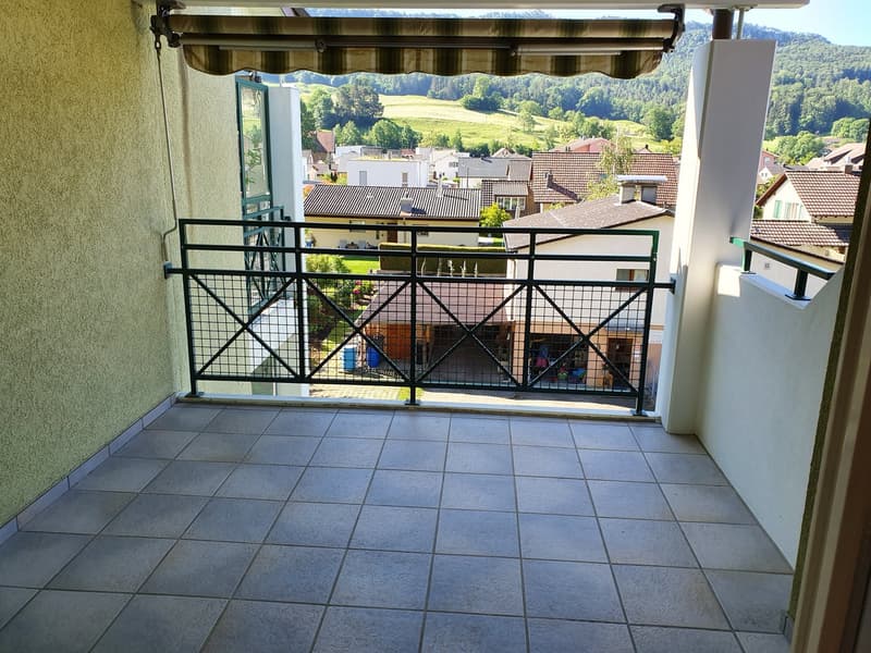 tiled balcony, metal railings, shade awning, town view