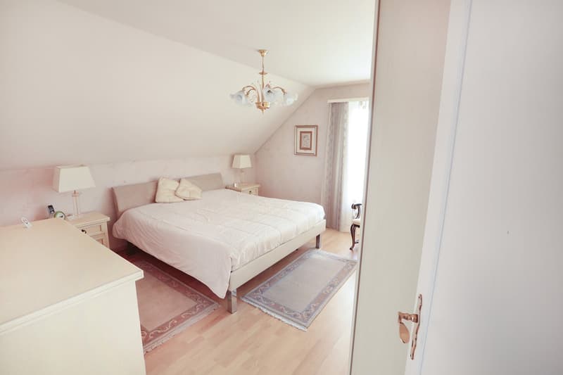 bedroom with bed, nightstands, lamps, rug, picture frame, wooden floor