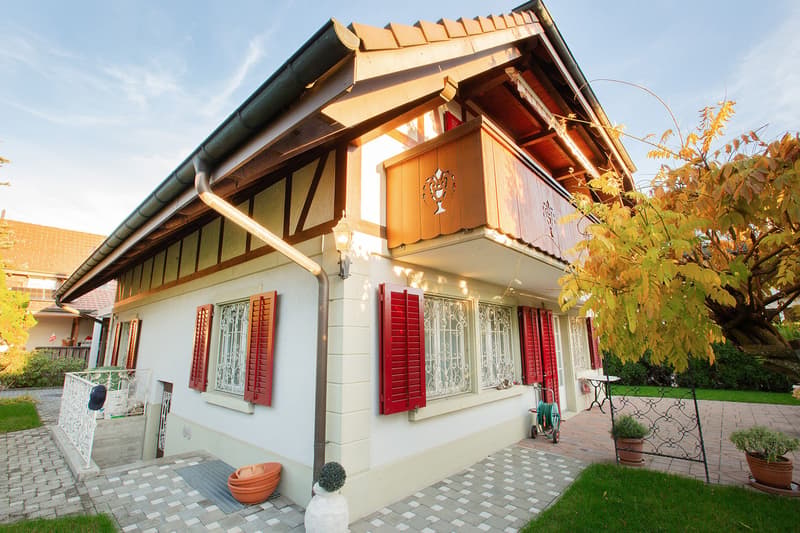 white house, red shutters, balcony, brick pathway, garden, tree