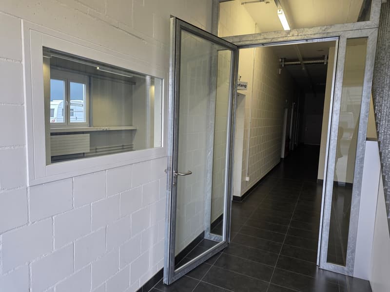 white brick walls, glass doors, black tiled floor, fluorescent lighting on the ceiling