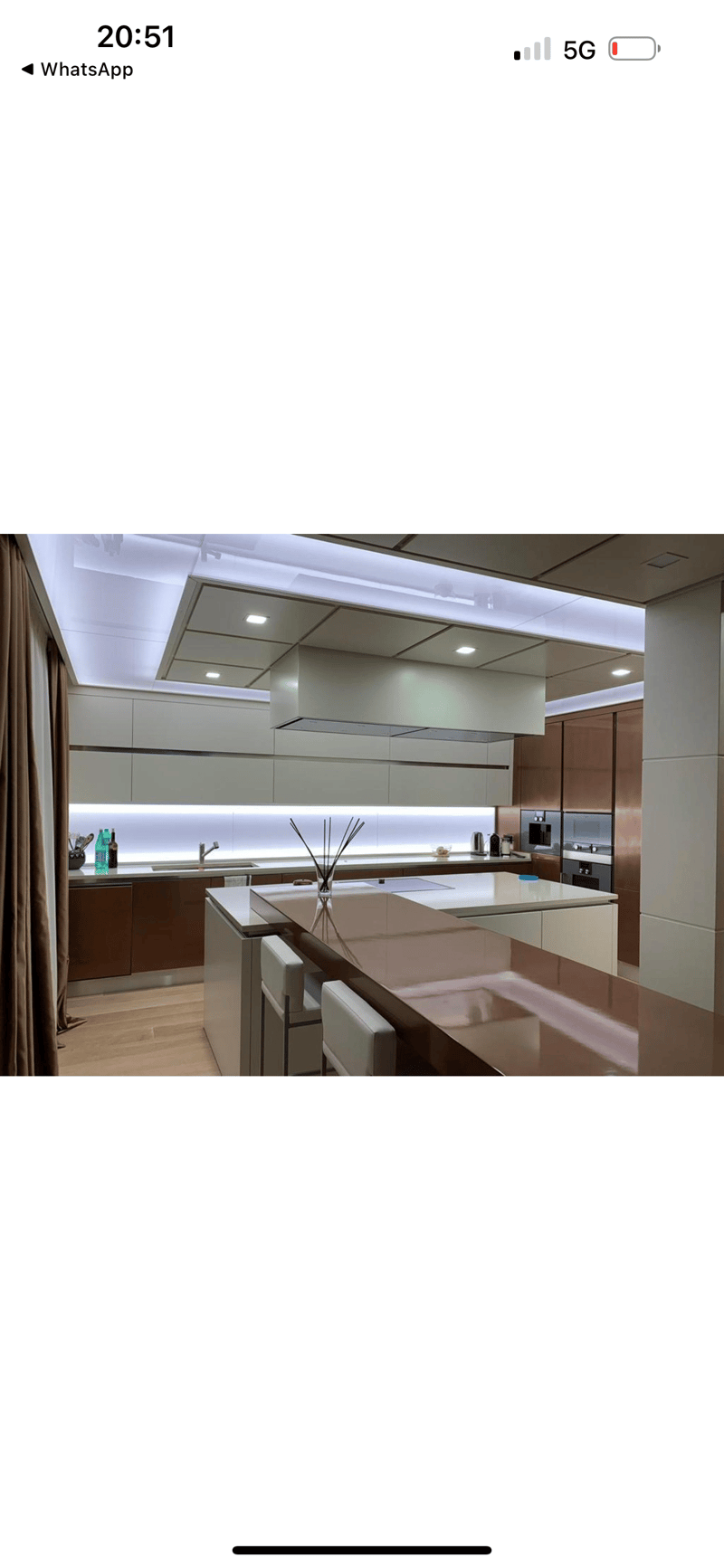 Modern, high-end kitchen with sleek gray cabinets, stainless steel appliances, and a large central island with a built-in dishwasher.