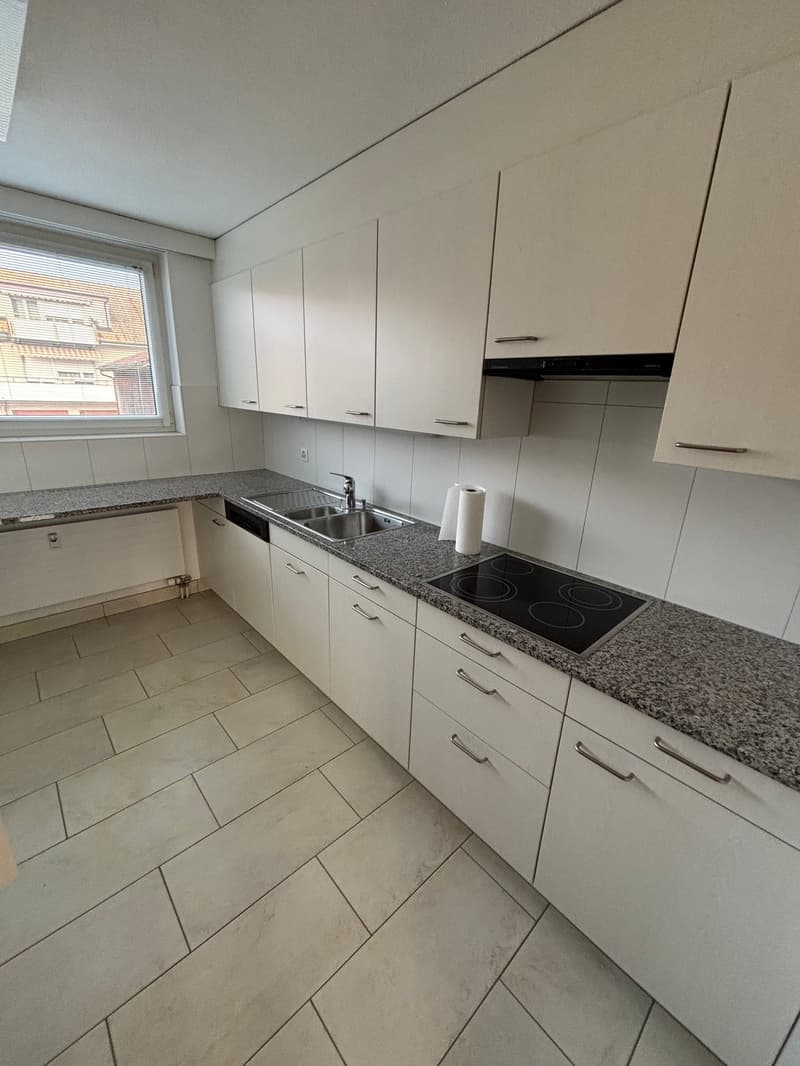 modern kitchen, tile floor, granite countertops, white cabinets, stainless steel sink, gas stove, dishwasher