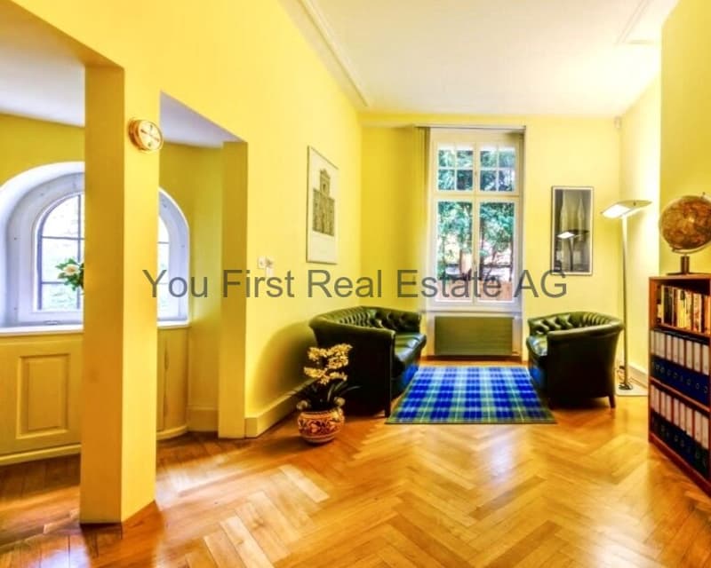 Stilvoller Altbau-Salon mit Charme: Lichtdurchfluteter Wohnbereich mit Fischgrät-Parkett und Bogenfenstern