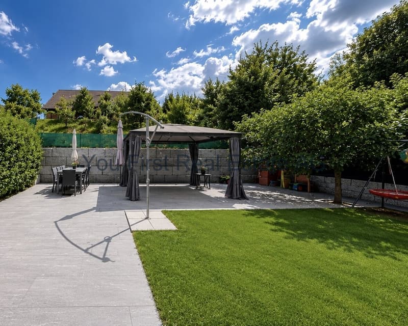 Terrassenbereich mit hochwertiger Natursteinanlage und integrierter Pergola