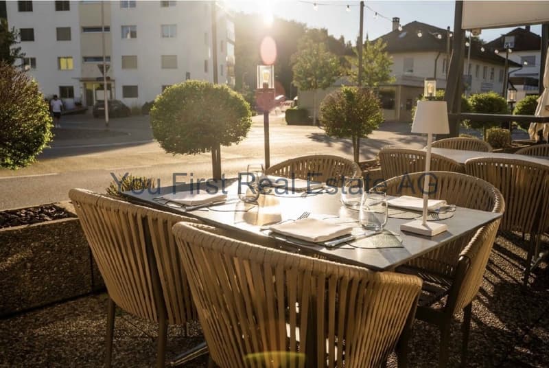 Sonnendurchflutete Terrasse mit integrierter Gastronomiefläche und Blick auf den Innenhof