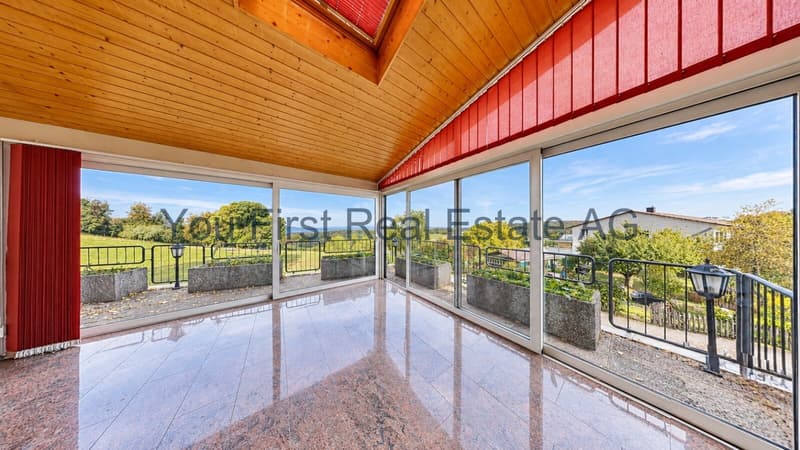 Verglaste Loggia mit Holzdecke und freiem Landschaftsblick