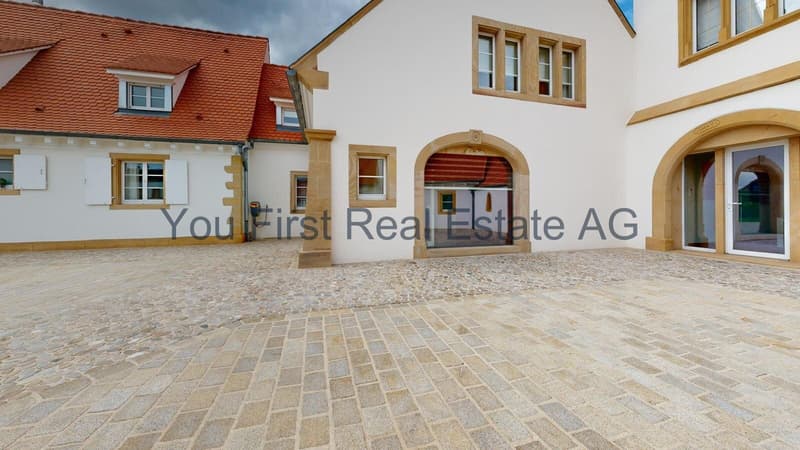 Repräsentative Innenhofanlage mit Natursteinpflaster und Bogeneingängen