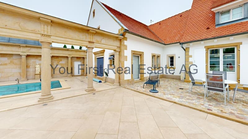 Überdachte Innenhofterrasse mit Säulengang und Poolhaus