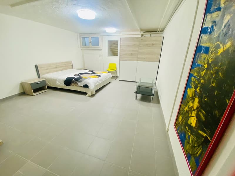 Single bedroom with a bed, nightstand, a painting, a chair, and a table