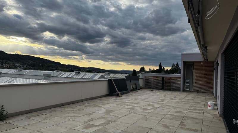Roof terrace with tiled flooring, white walls, panoramic view of the surrounding landscape, ladder, broom, bucket