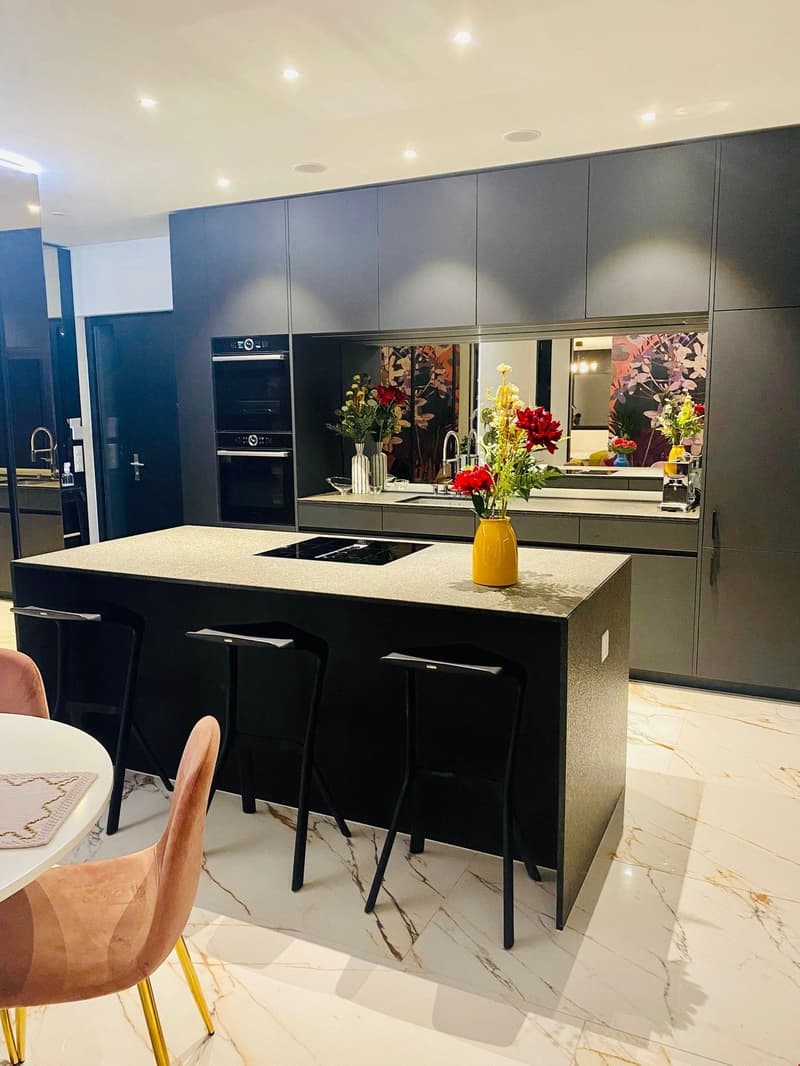 contemporary kitchen, marble countertops, island with stove, center table with chairs, large cabinets, built-in oven, marble flooring