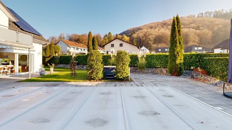 detached house, paved parking area, solar panels on the roof, spacious garden