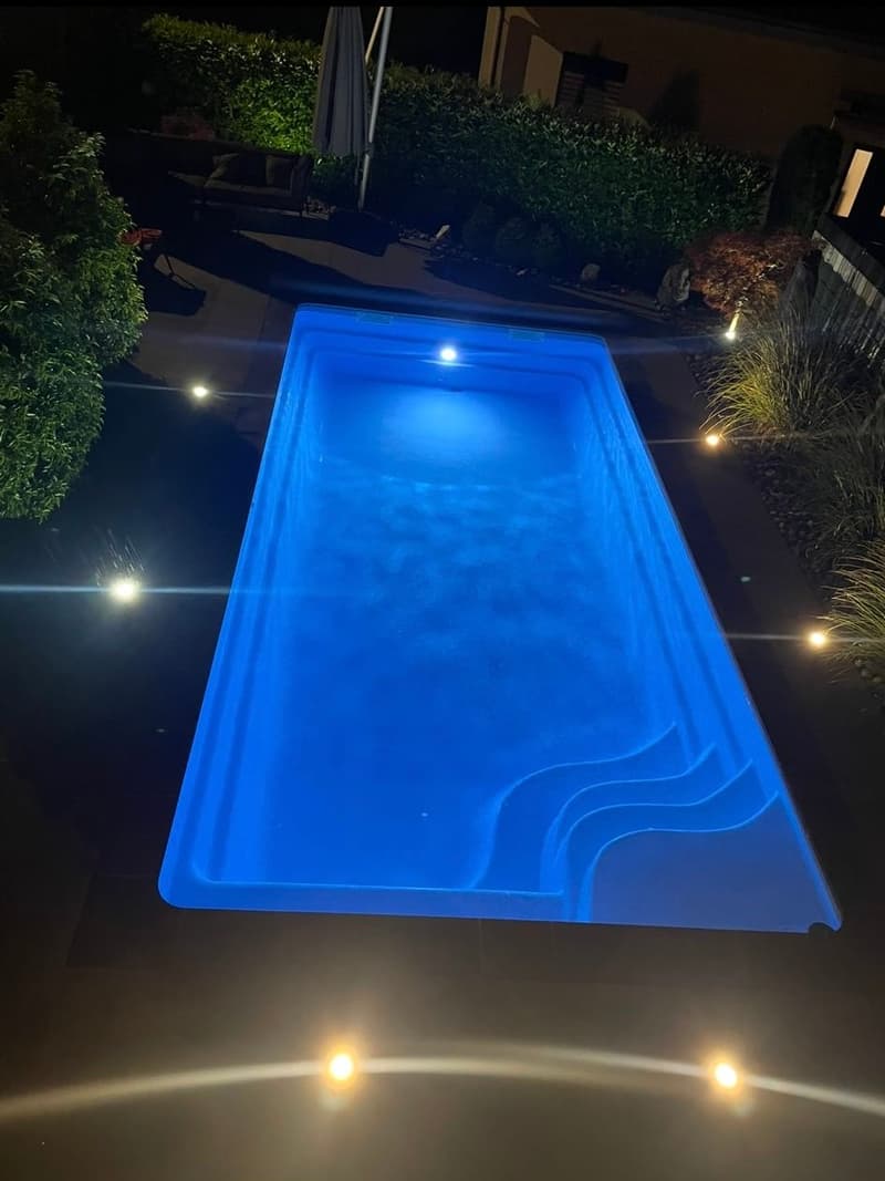 rectangular swimming pool, blue water, underwater lights, garden