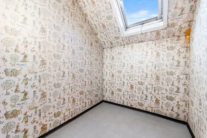 walls are decorated with wallpaper, the wallpaper features drawings of people, houses, and other objects, skylight window